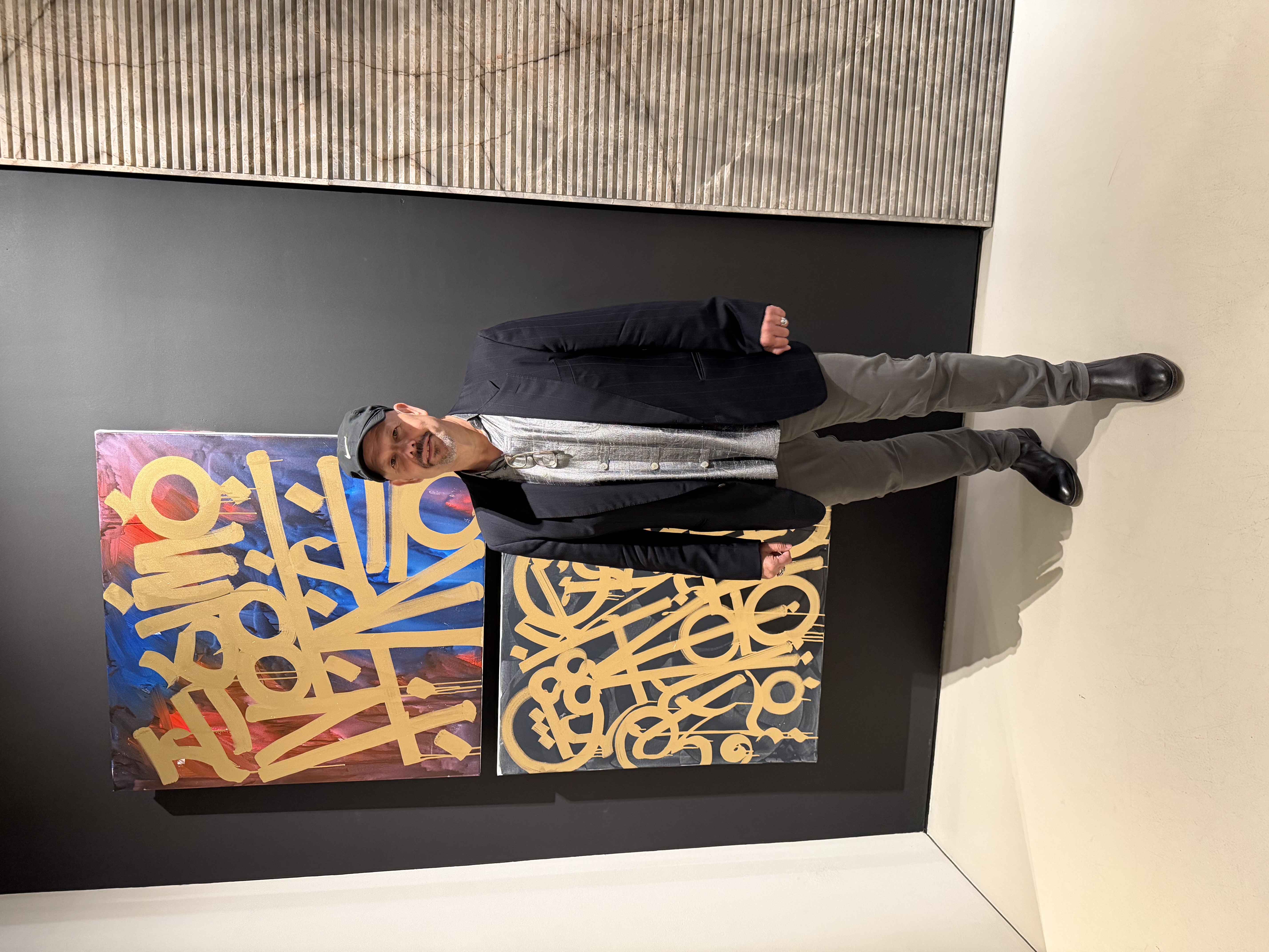 Conan Brooks, professional appraiser, standing with artwork in the gallery