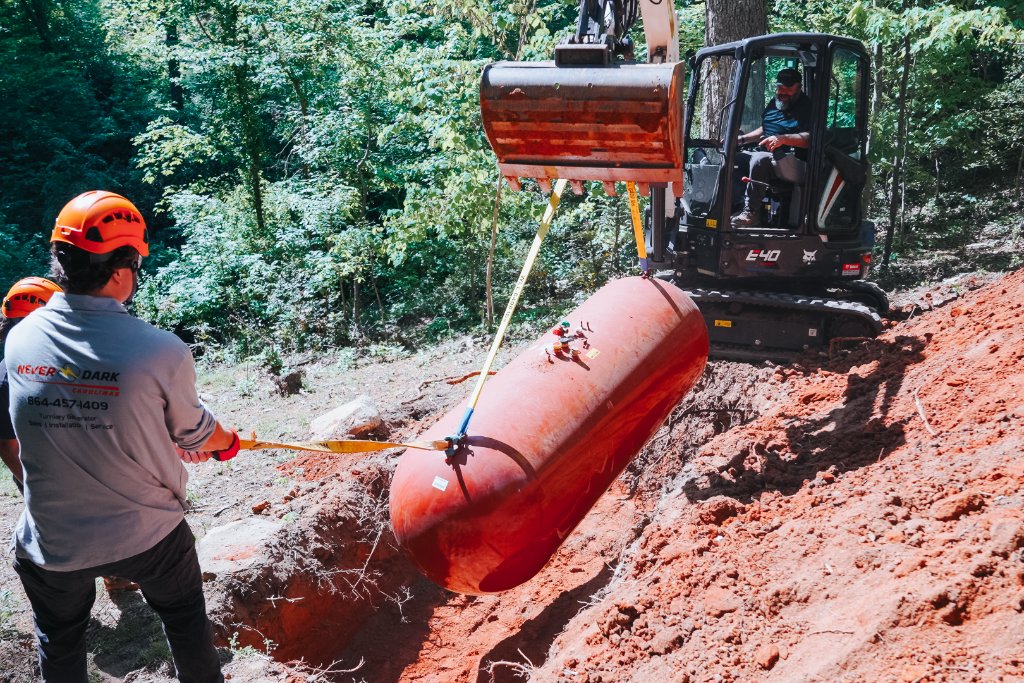 Never Dark Carolinas technician installing a propane tank for a standby generator using an excavator