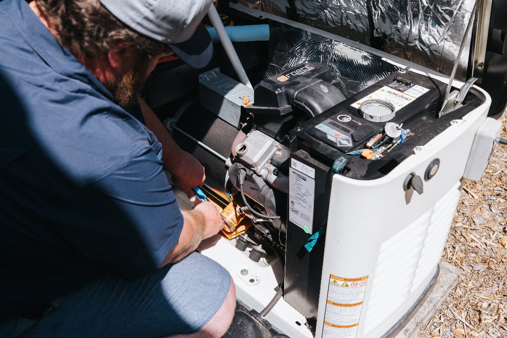 Never Dark Carolinas technician maintaining internal components of a standby generator