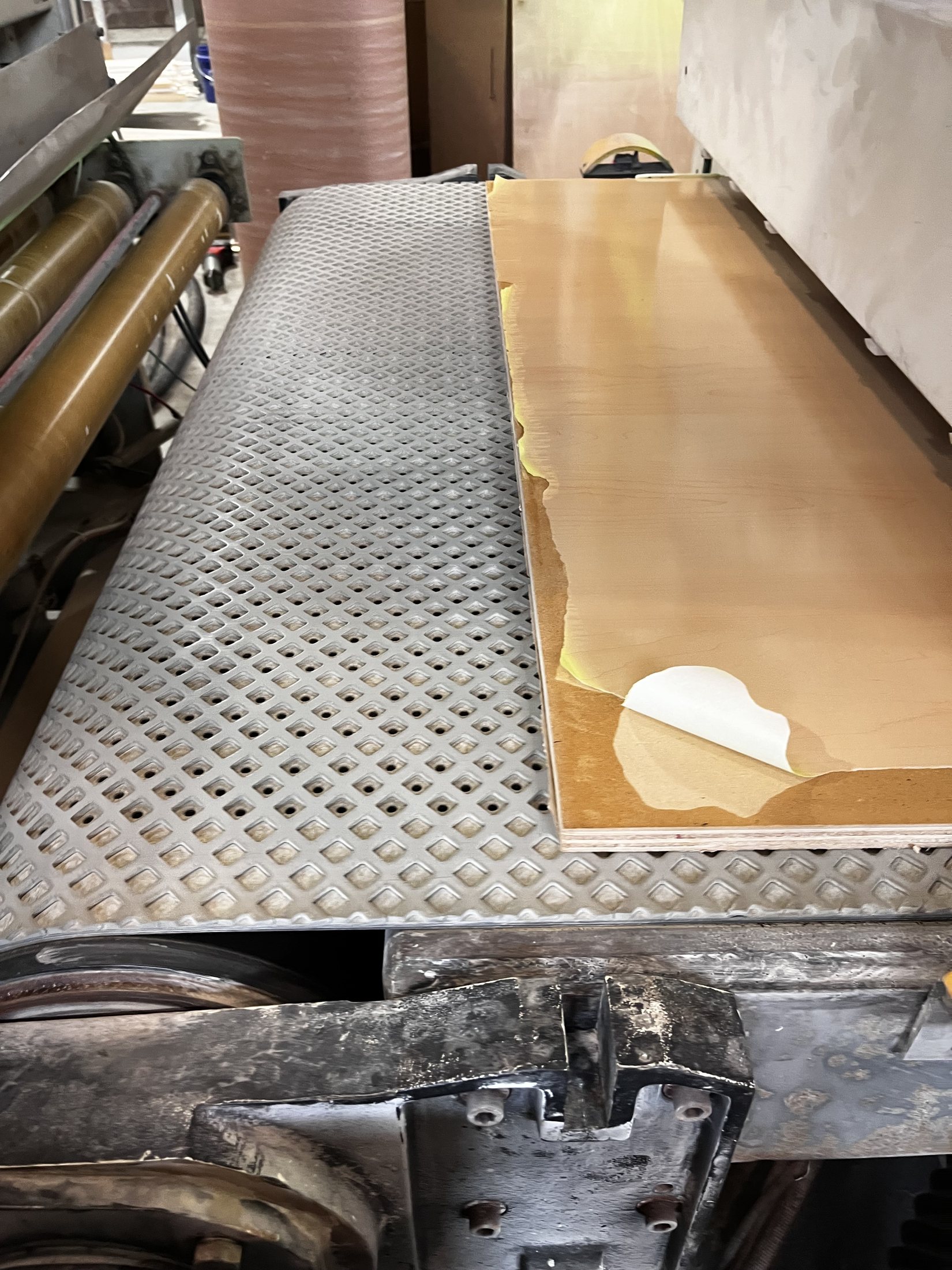 A wide-belt sander running a coated panel through a process trial.