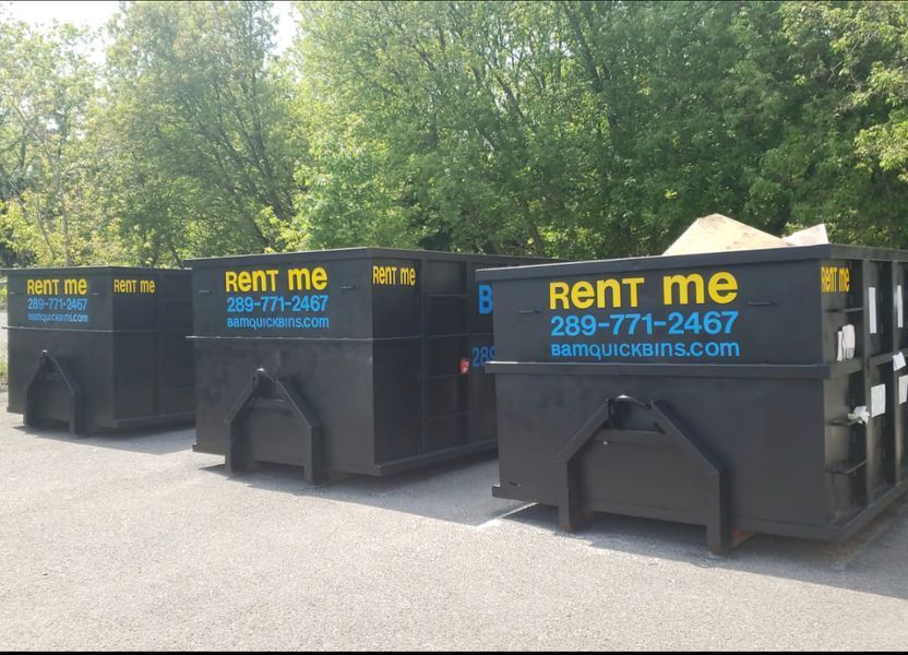 Three black BAM bins with branding and contact info