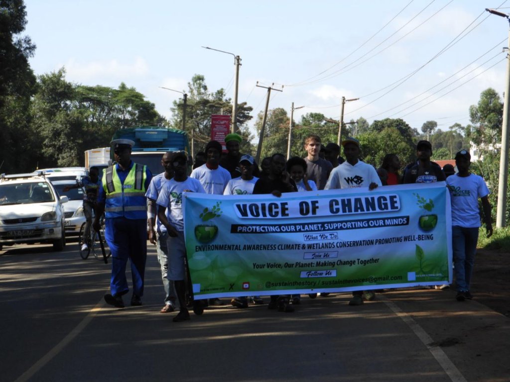 Community members marching with the Voice of Change banner along a Limuru road during the February 2025 Walk for Wetlands