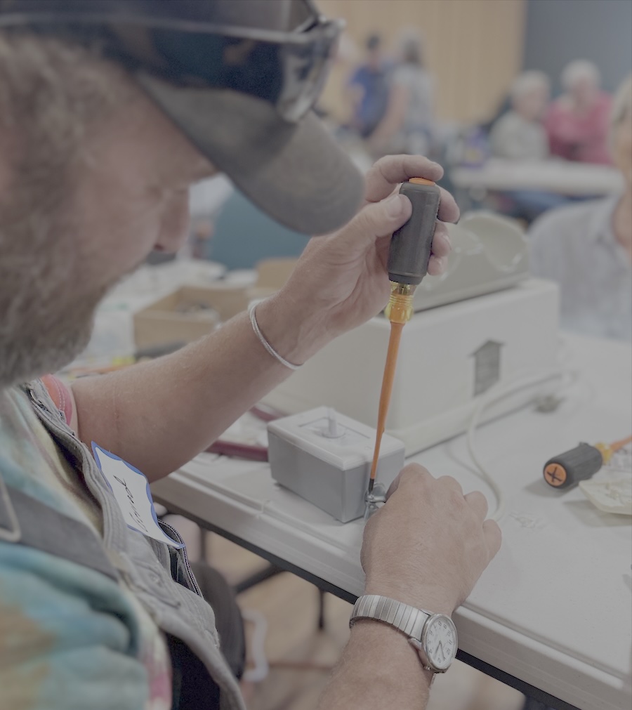 Bustling community repair café event with volunteers and community members fixing items together