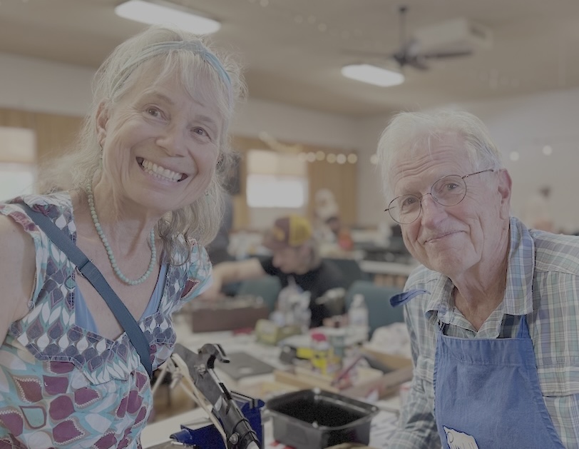 Two volunteers working together to repair a vintage lamp at a community repair event