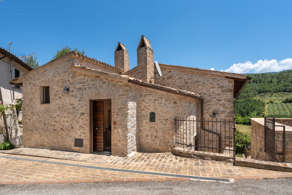 Stone farmhouse facade with arched doorway