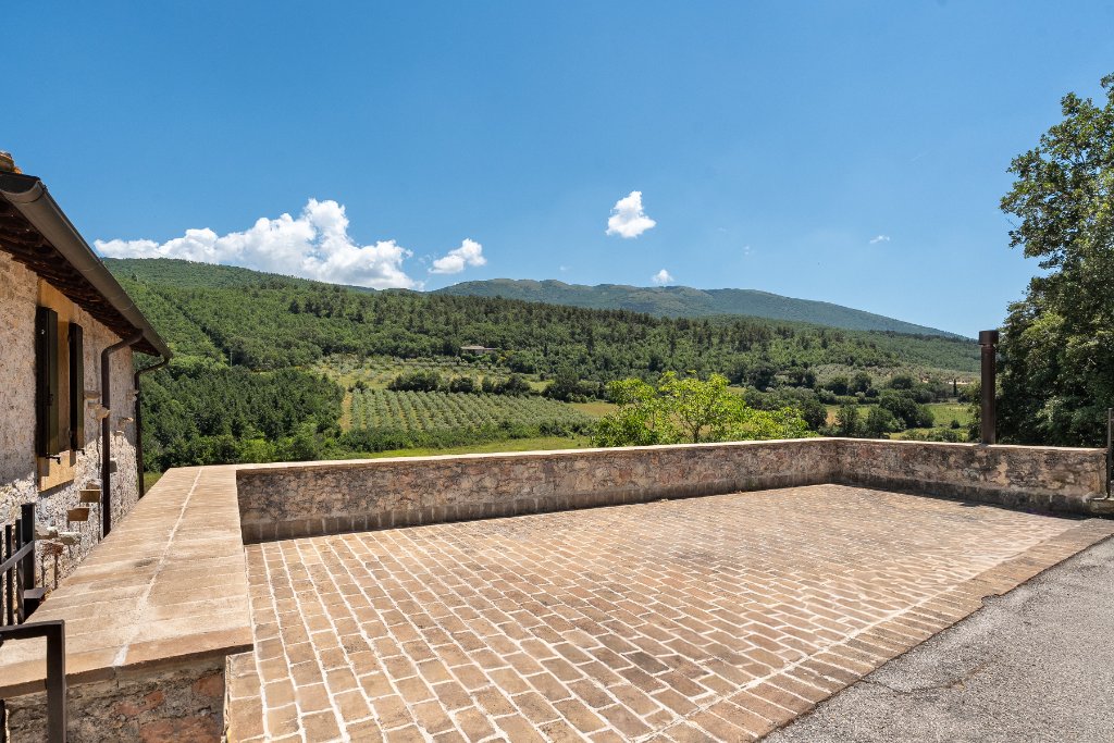 Stone terrace overlooking olive groves and rolling hills
