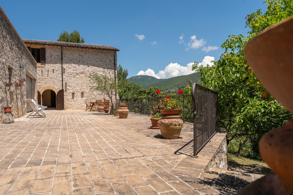 Terrace with terracotta pots, arched doorway, and valley views