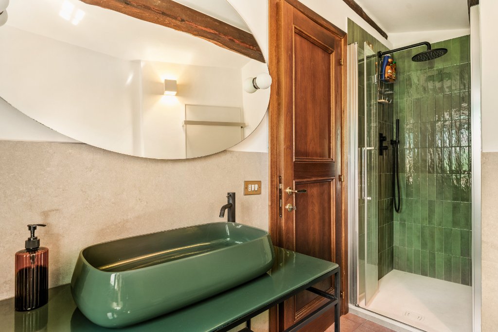 Bathroom with green vessel sink and shower