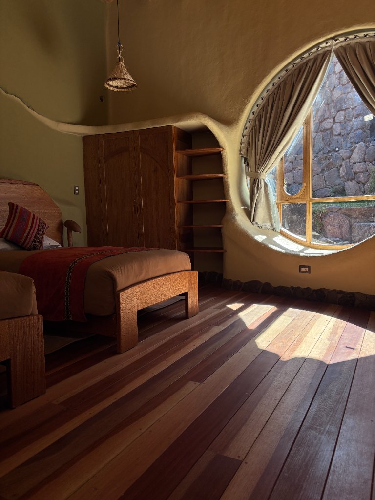 Double room with a circular window and wood floors