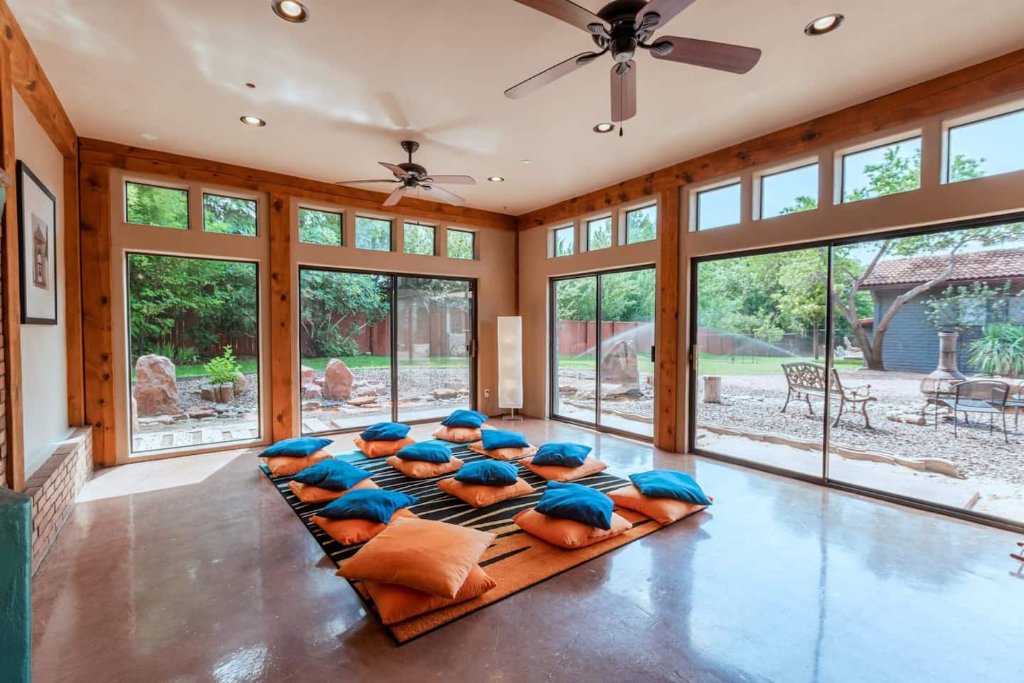 Glass-walled yoga and movement studio with floor cushions