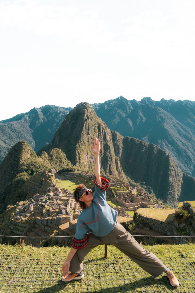 A woman in a yoga pose overlooking Machu Picchu in the Sacred Valley of Peru