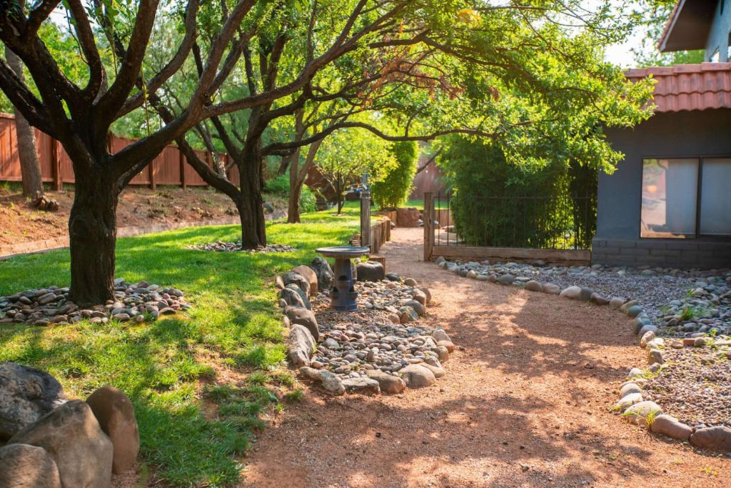 Shaded garden pathway with river rock landscaping