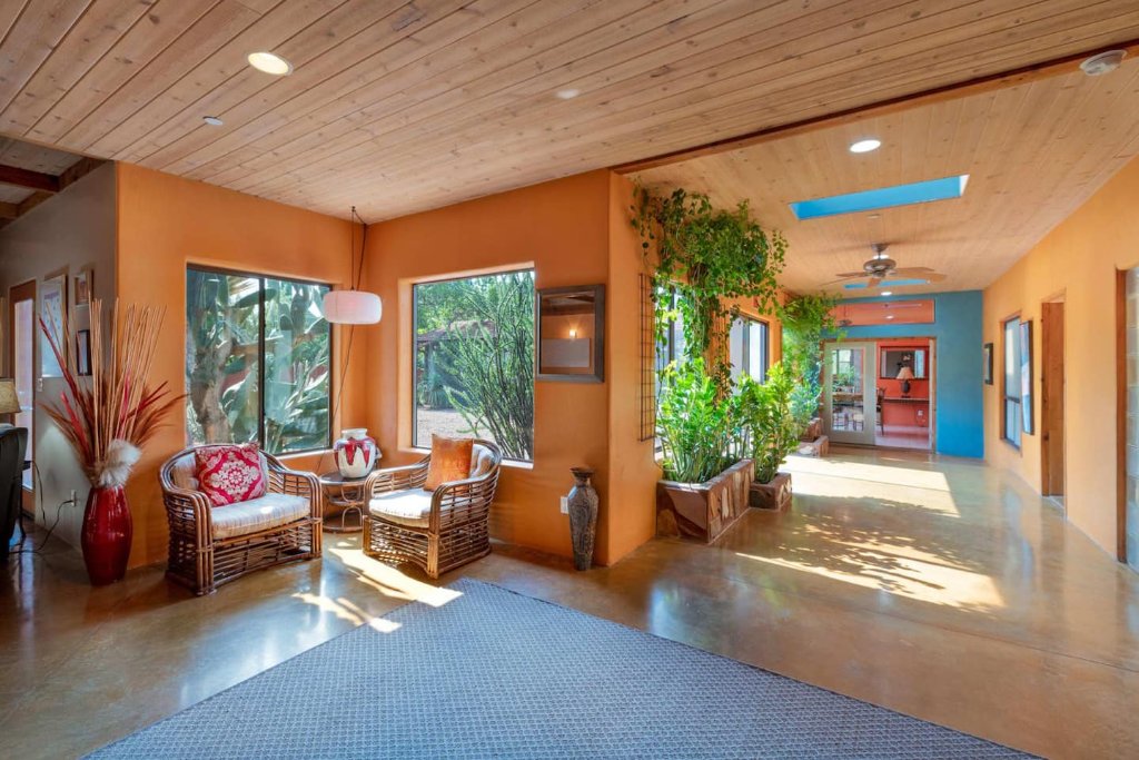 Sunlit interior hallway with natural light, plants, and a seating nook