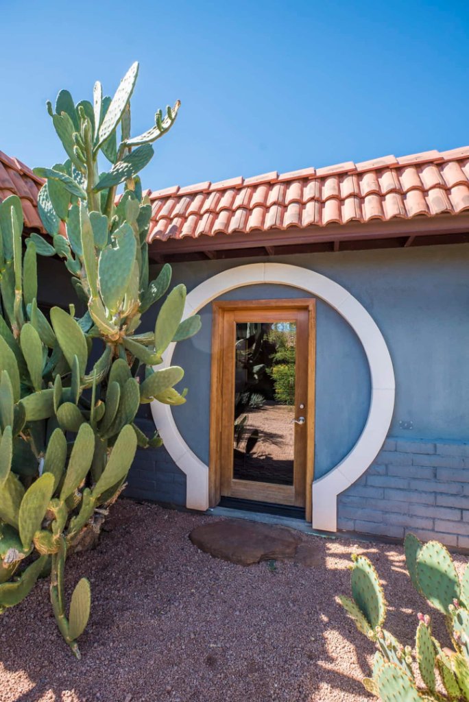 A round moon-gate doorway framed by desert cactus