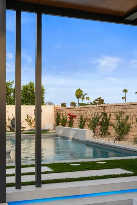 Evening view of a custom infinity edge pool in Huntington Beach, California