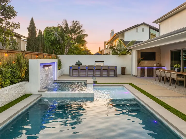 Custom pool and spa with sheer-descent water feature and fire pit at a Huntington Beach residence