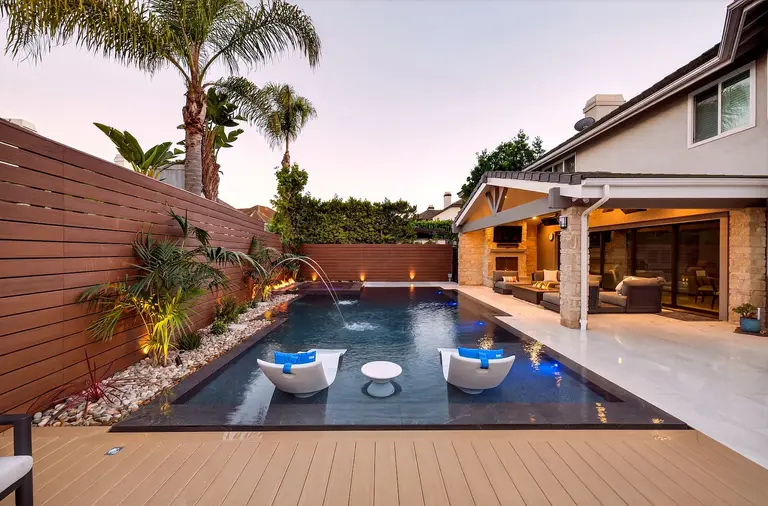 Luxury estate pool with fire pit, spa, and outdoor living features in Huntington Beach