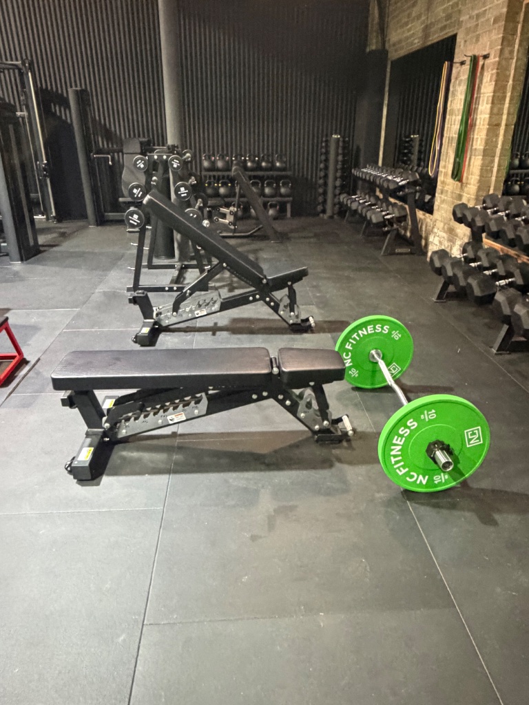 Free weights area with barbells and dumbbell racks