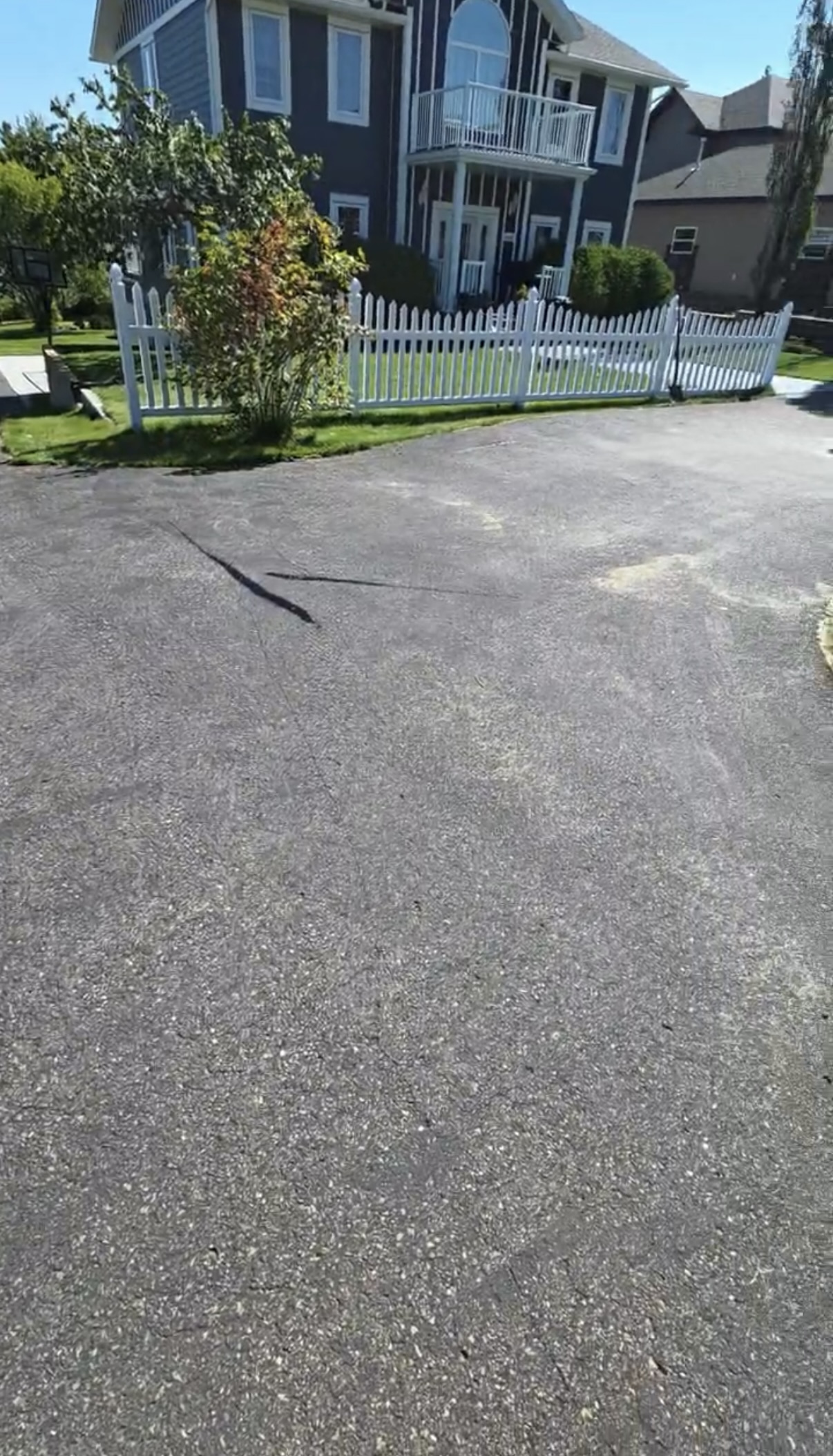 Aged, oxidized grey asphalt driveway before oil-based sealant