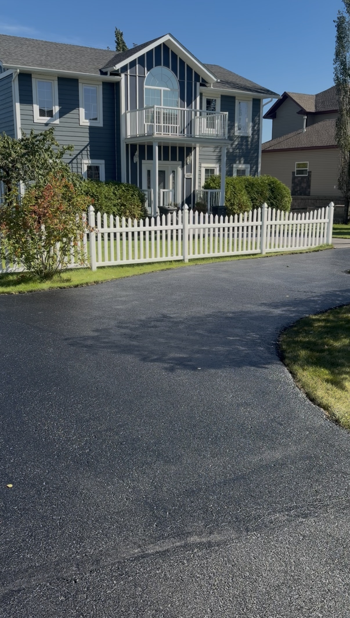 Same driveway restored to a deep black finish after oil-based sealant
