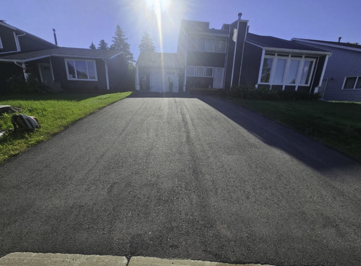 Oil-based sealant restoring a rich black finish on asphalt