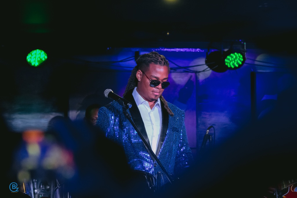 Kobie Alleyne performing in dramatic lighting