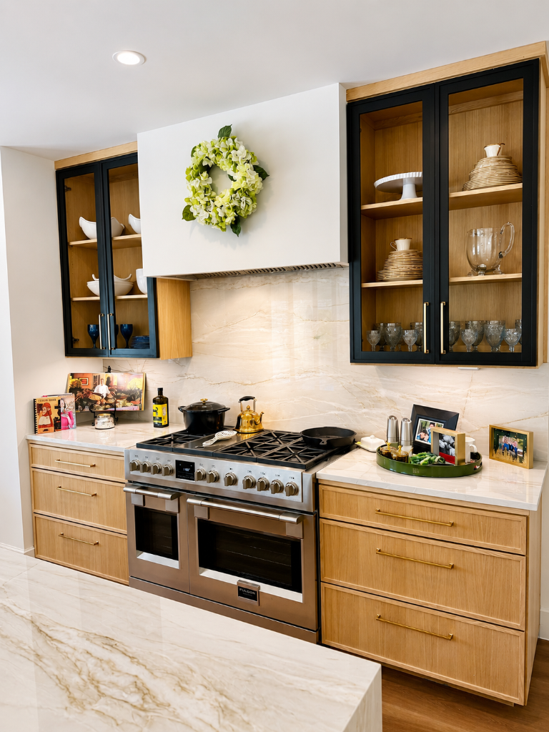 Professional range with stone slab backsplash, glass-front upper cabinets, and gold accents