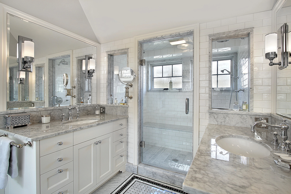Master bath with glass-enclosed shower, double vanity, freestanding tub, and marble floors