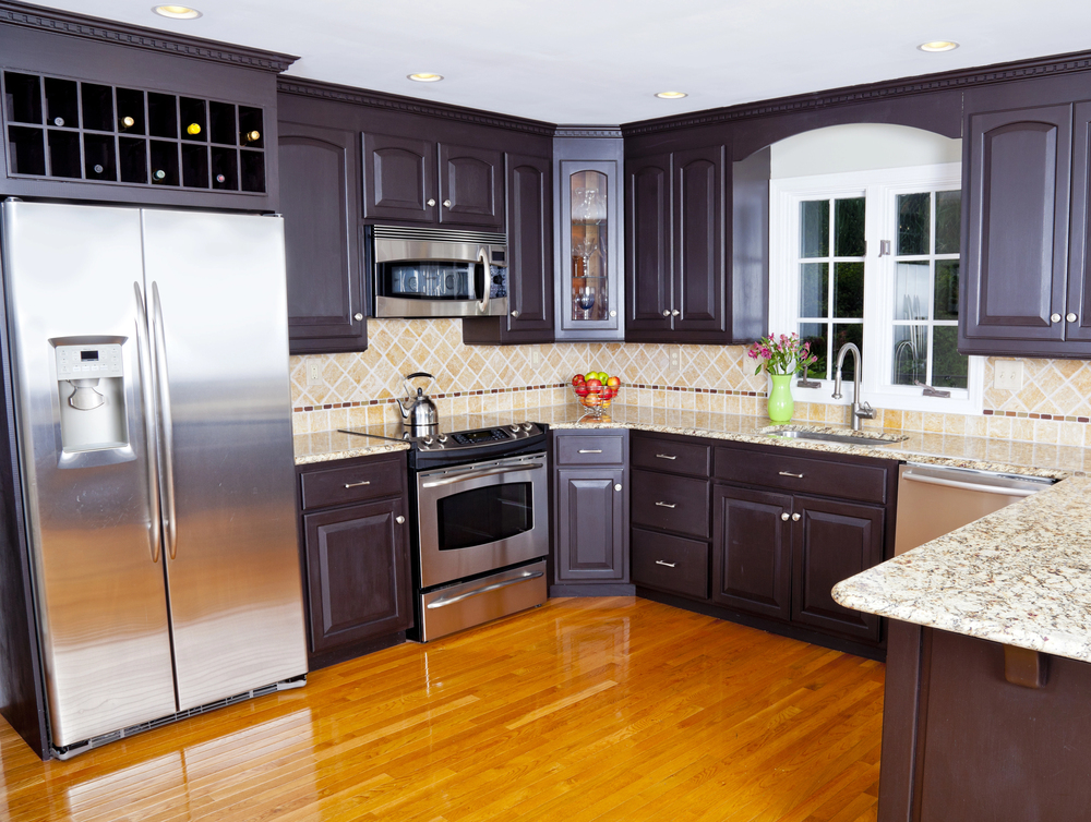 Espresso-stained kitchen with corner display cabinet, wine rack, and stone peninsula