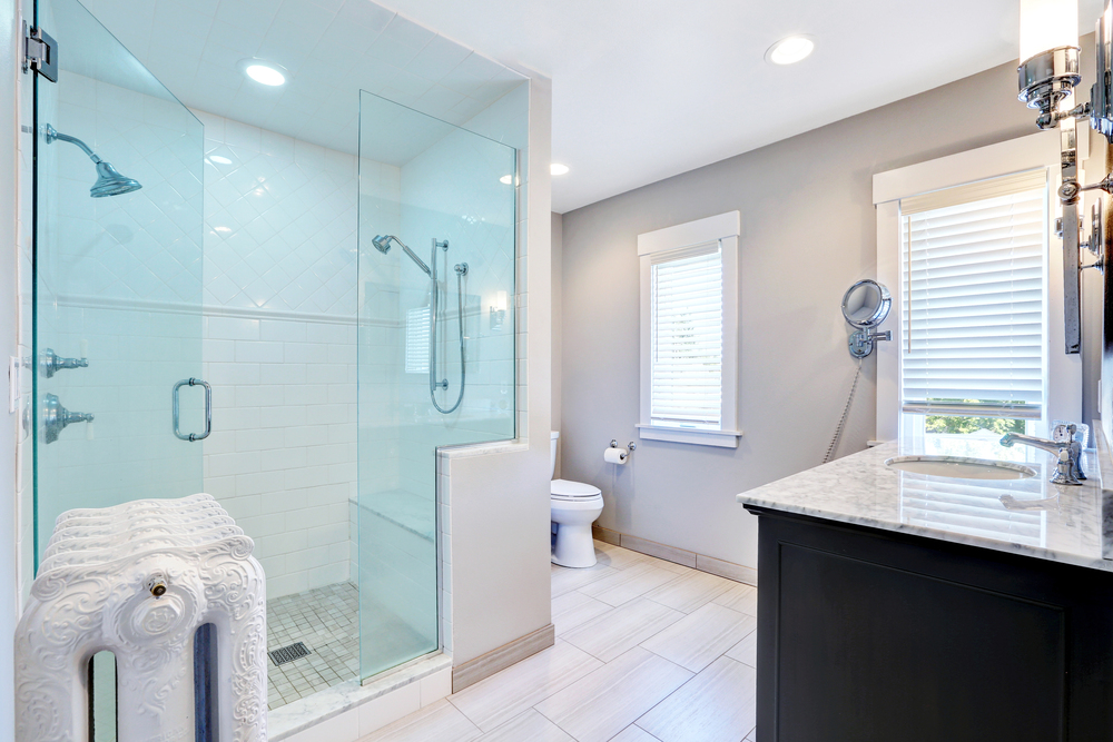 Modern bathroom with walk-in glass shower, charcoal vanity, and marble countertop