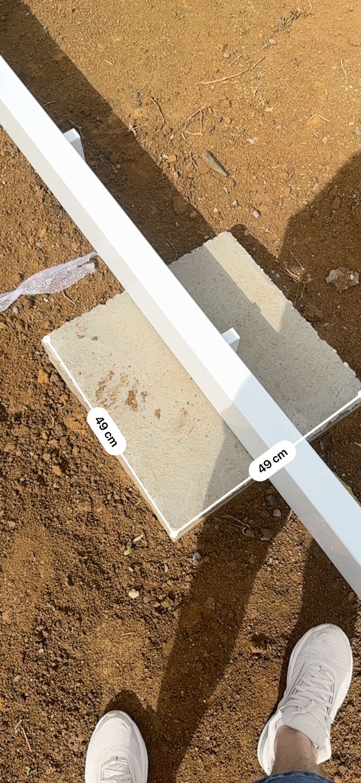 Bloco de fundação de concreto de 49 cm de lado apoiando a estrutura metálica