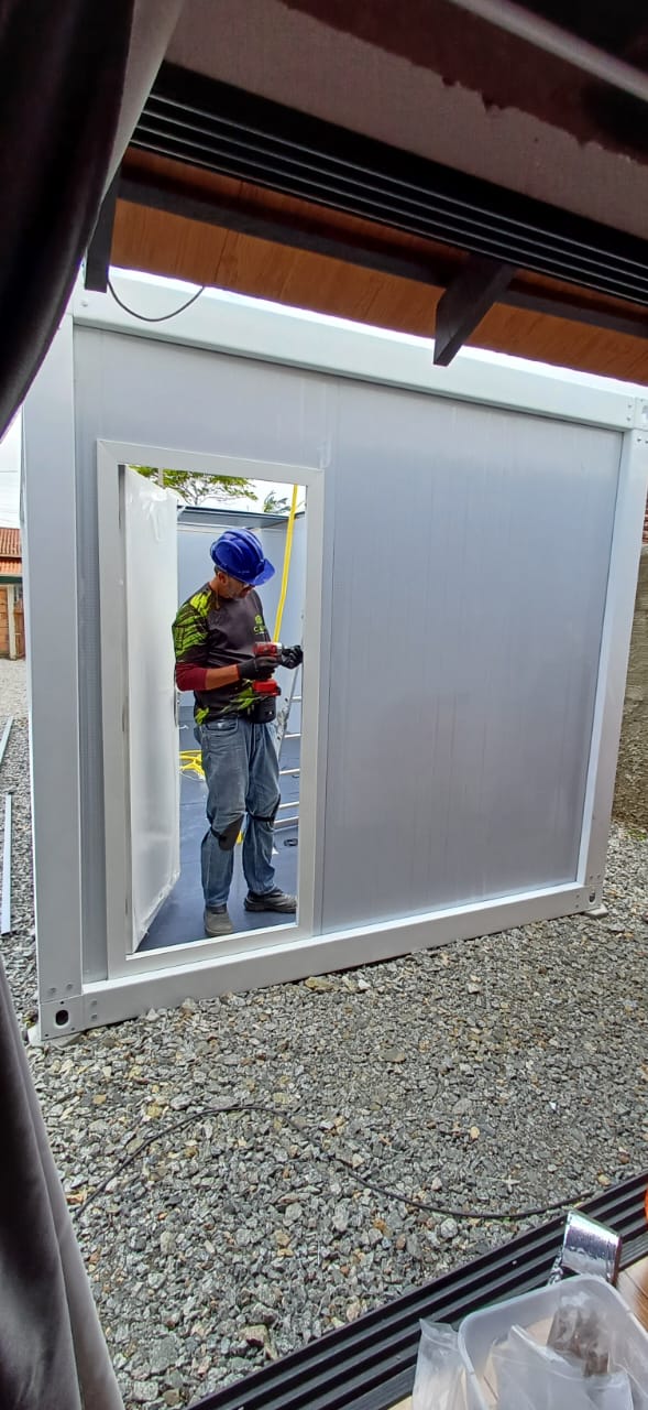 Funcionário instalando os painéis de parede do módulo durante a montagem