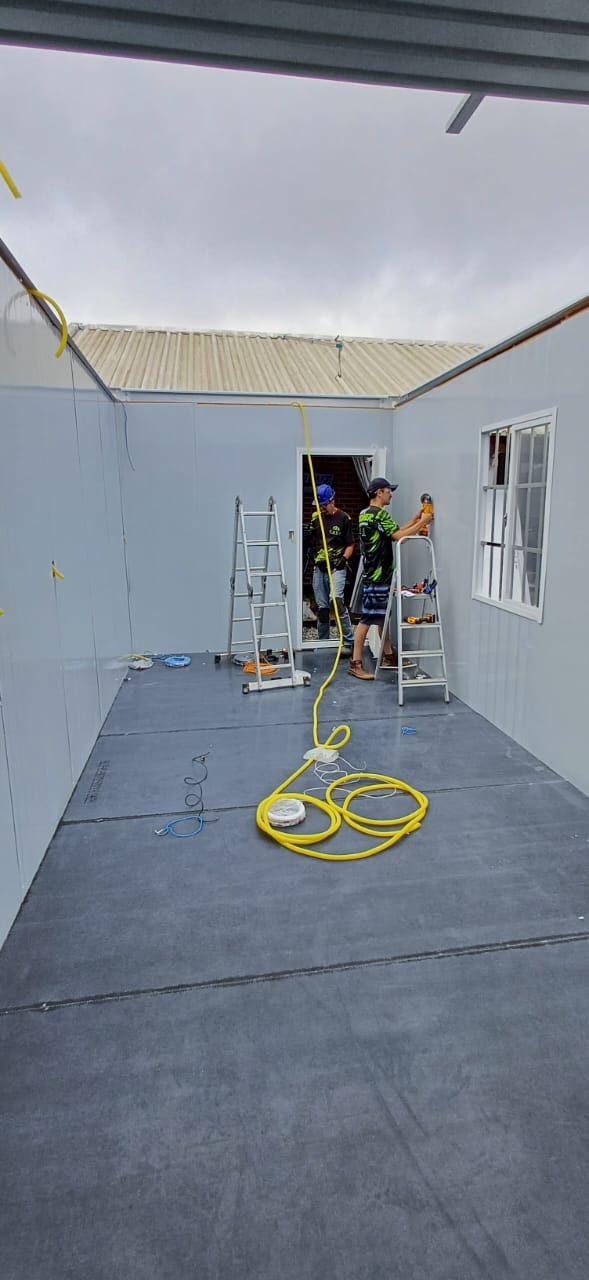 Equipe realizando instalações elétricas no interior do módulo