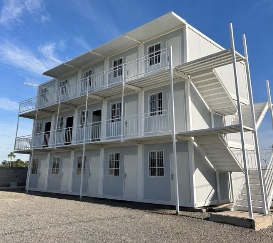 Edifício modular de três andares com varandas e escada externa
