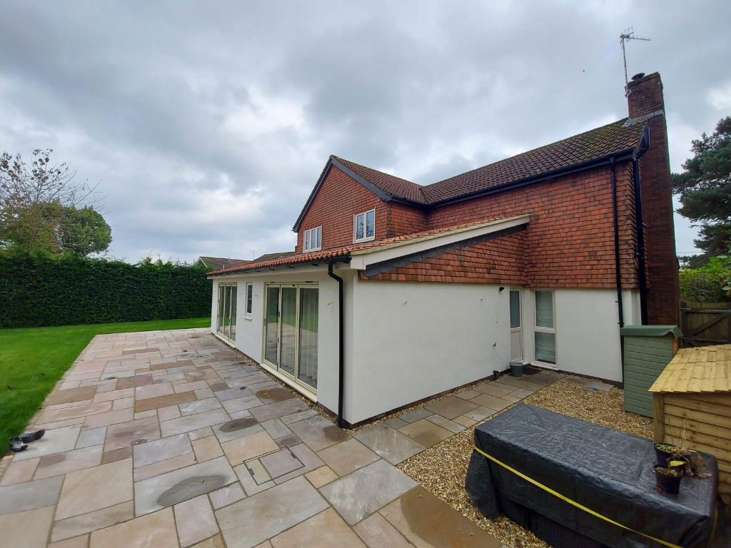 Side angle — render finish meeting original brickwork