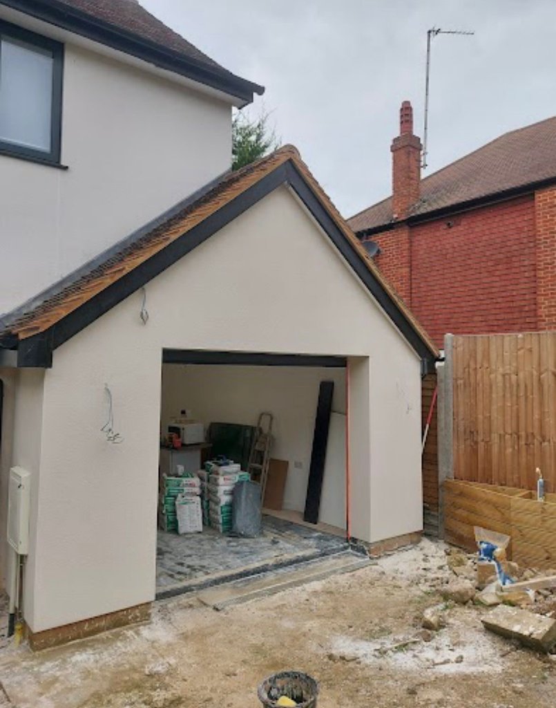 Gable-end extension with monocouche render alongside red brick house