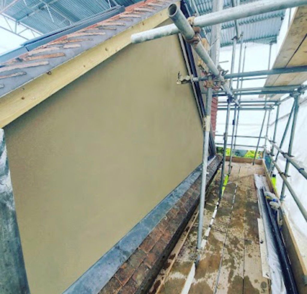 Sand and cement rendered gable end with scaffold access during loft conversion