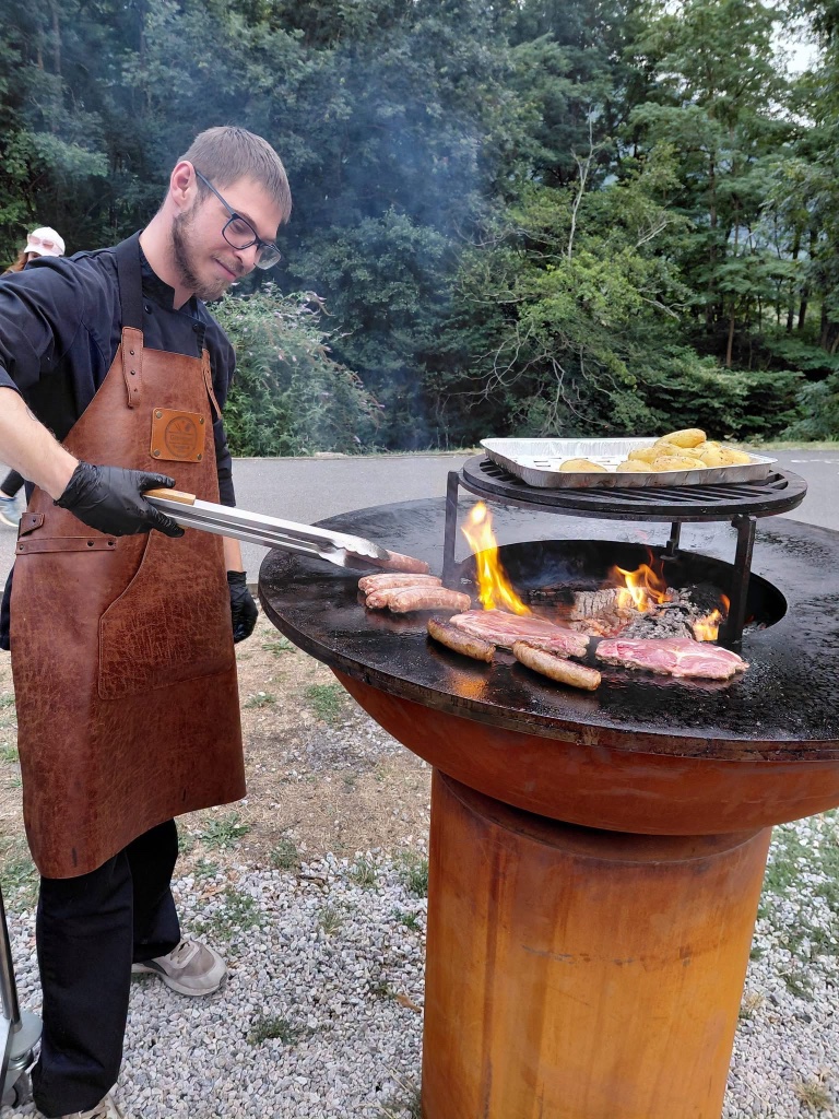 Le chef aux commandes du feu de bois et de la plancha