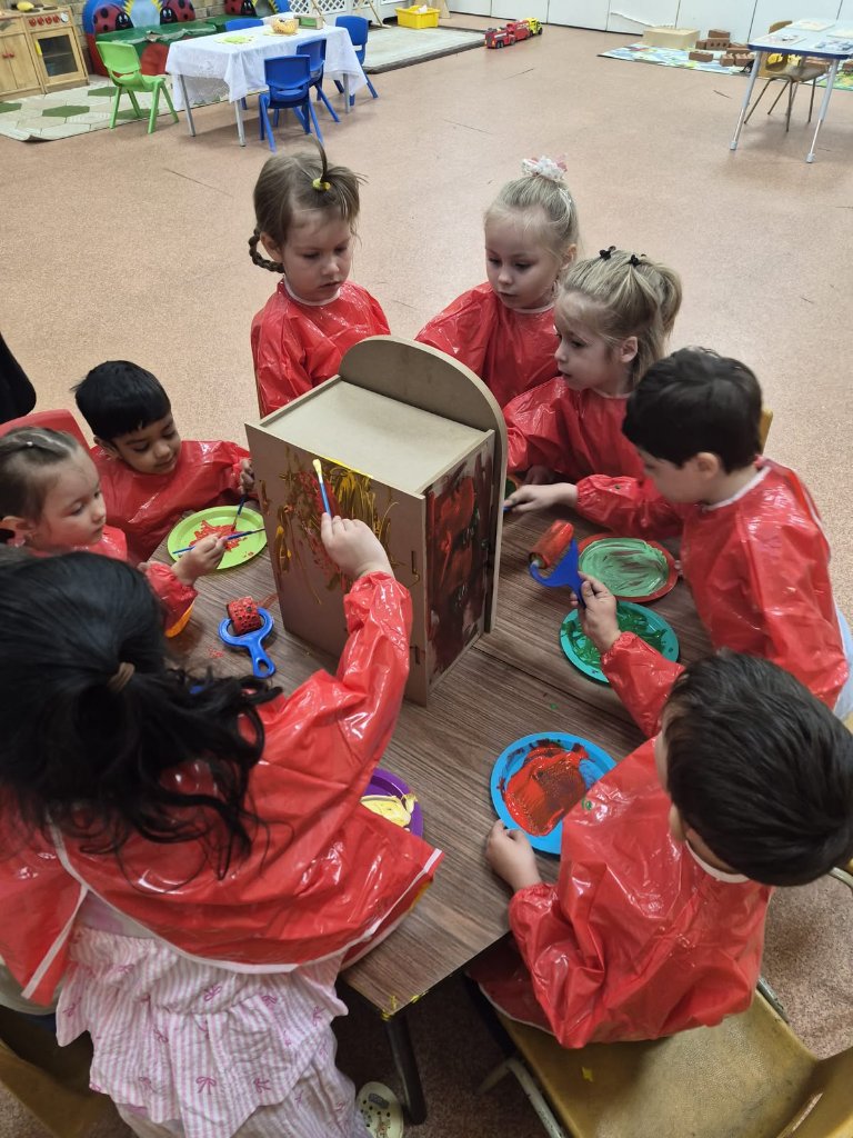 Children painting a wooden structure at Morning Glory Pre-School