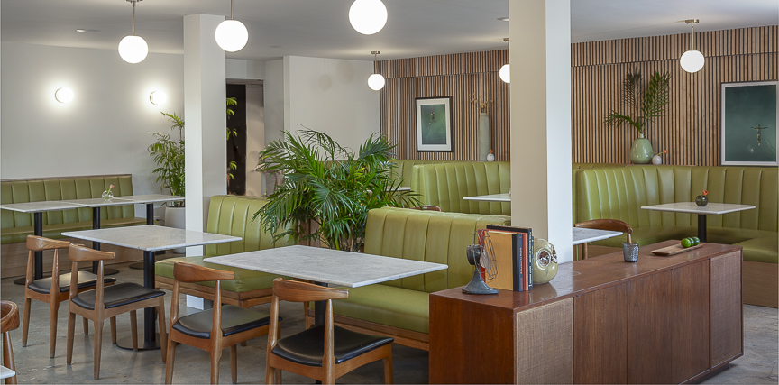 Dining room booths against wood slat walls with palm plants