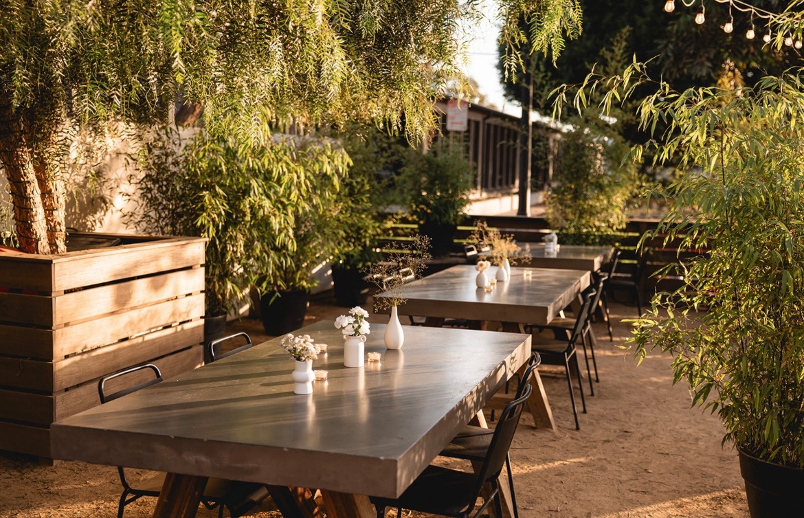 Concrete dining tables on the garden patio at golden hour