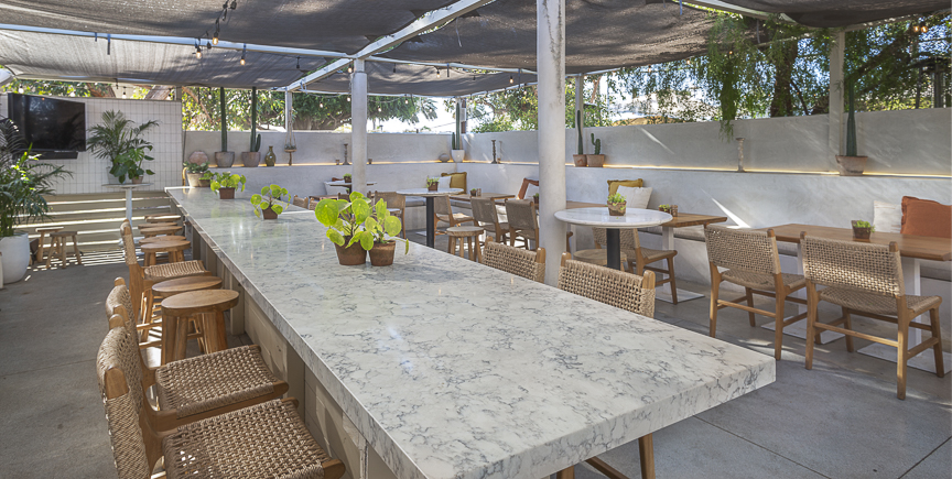Marble bar counter with woven stools on the covered patio