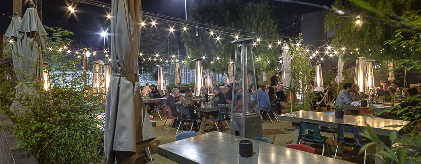 Garden patio with heaters and bistro lights at night