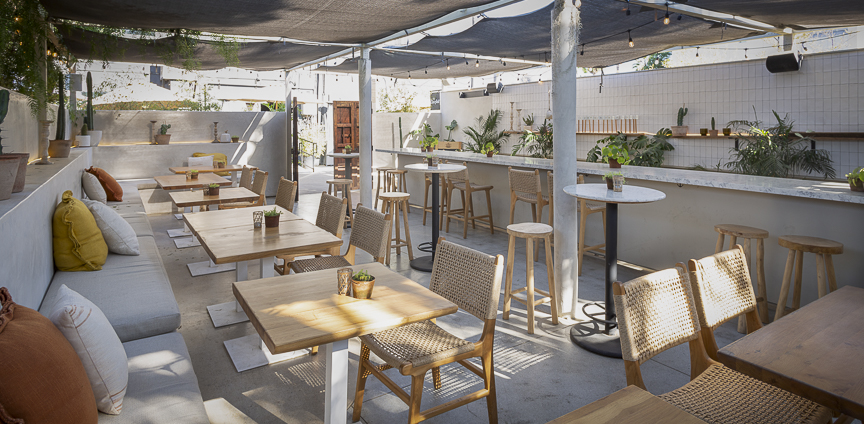 Patio dining tables beneath strung lights