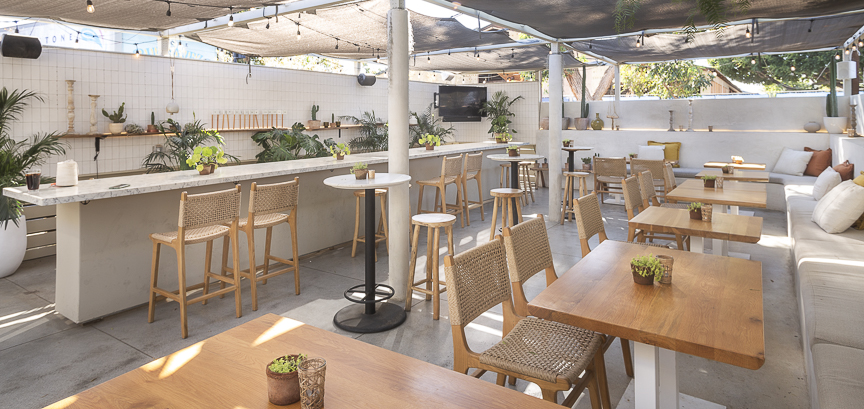 Covered patio with marble tables and cushioned banquette seating