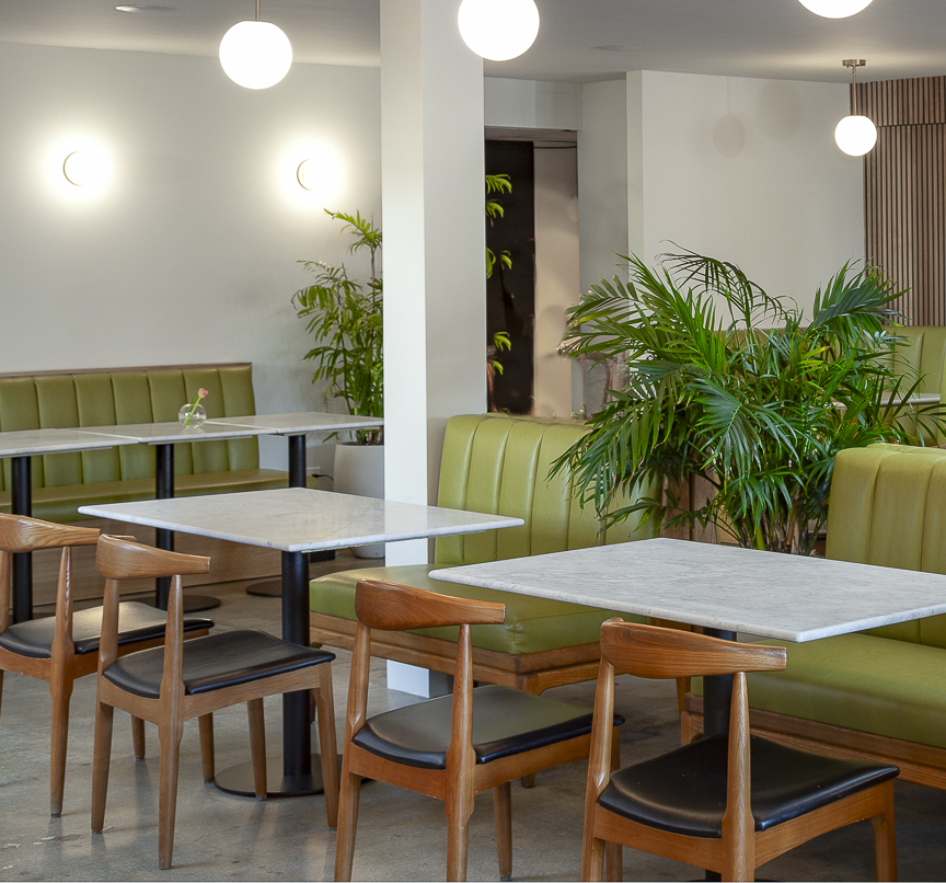 Olive green booths and marble tables in the dining room