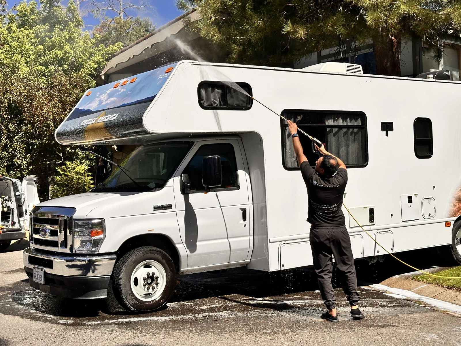 TheWashMen team member working beside a motorhome and mobile service vehicle