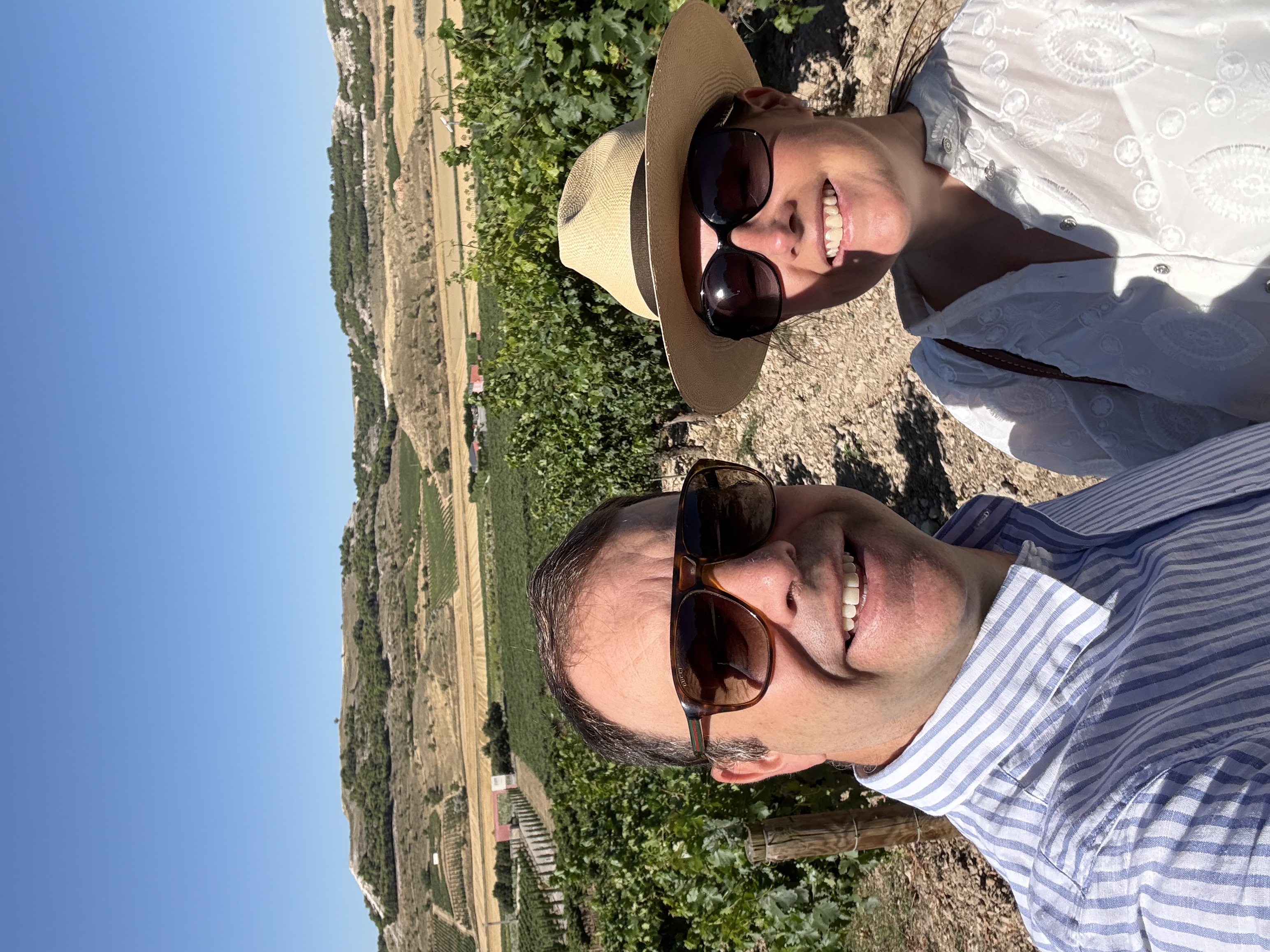 The founders of VinoVin standing together in a vineyard on a sunny day