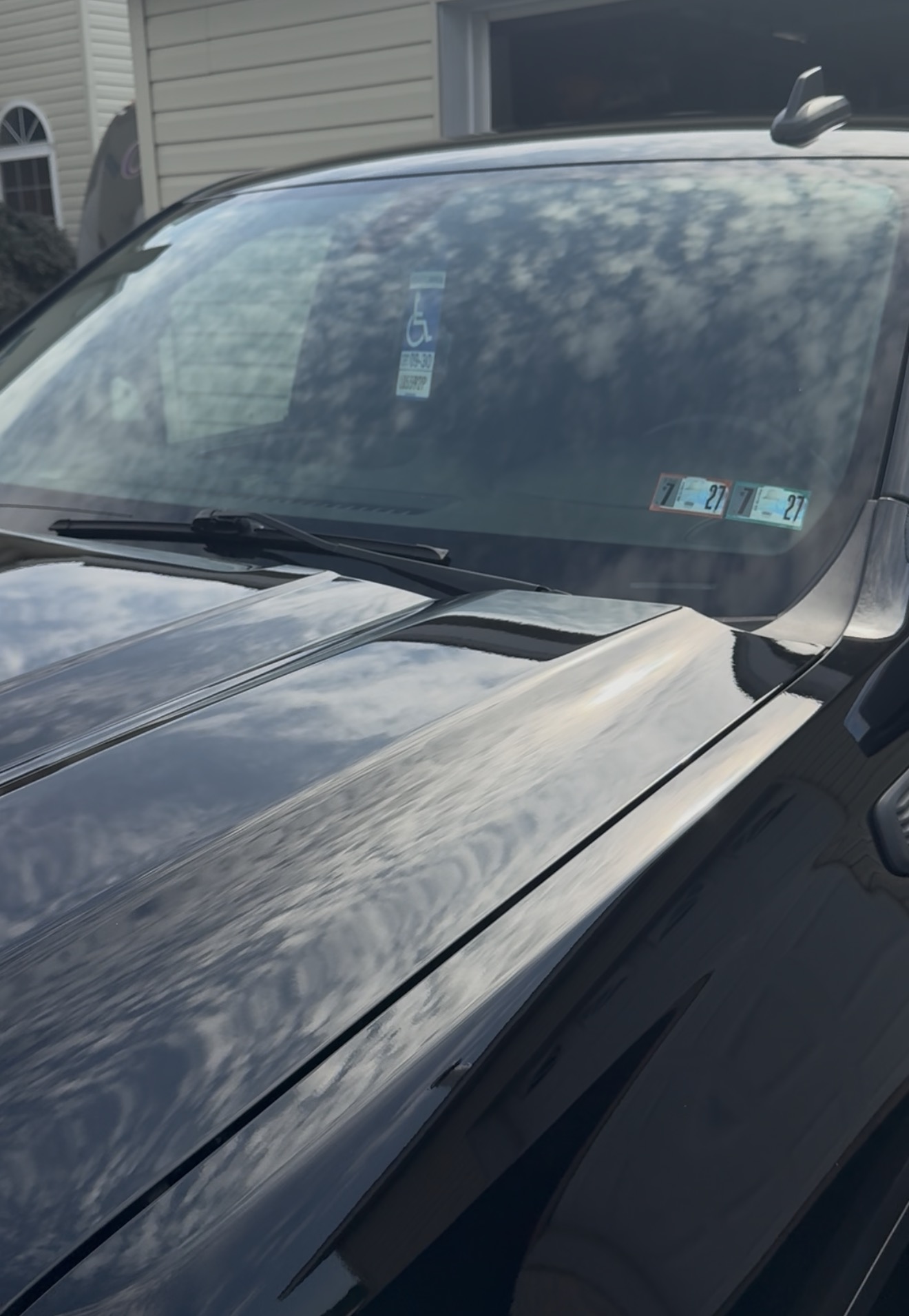 Black vehicle hood with mirror-like clarity after paint correction and ceramic coating