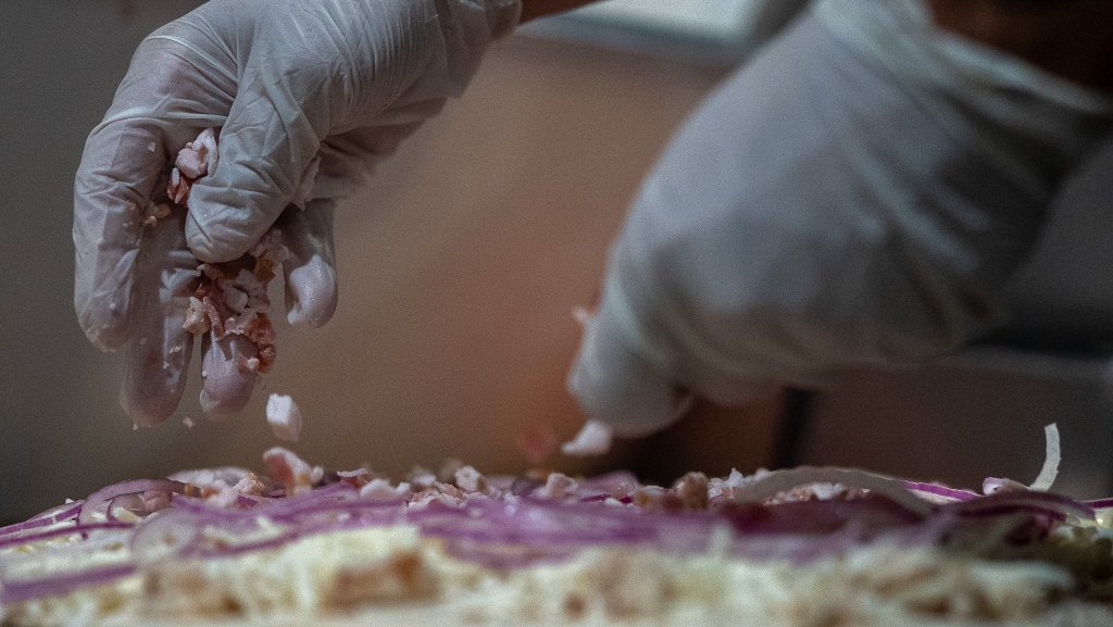 Topping a fresh pizza